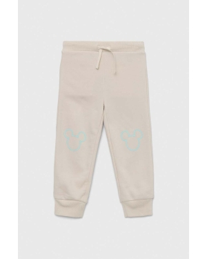 GAP spodnie dresowe dziecięce x Disney kolor beżowy z nadrukiem
