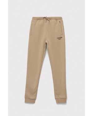 Calvin Klein Jeans spodnie dresowe dziecięce kolor beżowy gładkie
