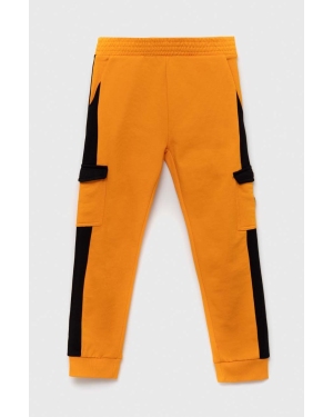 Guess spodnie dresowe bawełniane dziecięce kolor pomarańczowy wzorzyste