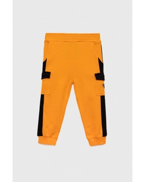 Guess spodnie dresowe bawełniane dziecięce kolor pomarańczowy wzorzyste
