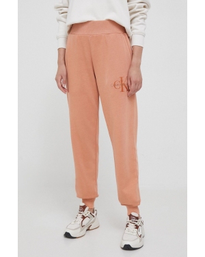 Calvin Klein Jeans spodnie dresowe bawełniane kolor pomarańczowy gładkie