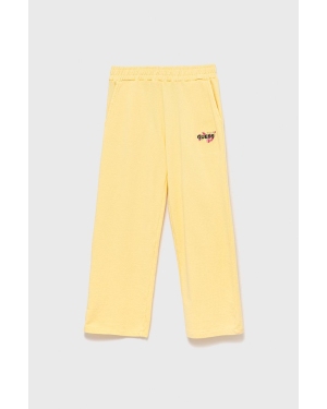 Guess spodnie dresowe dziecięce kolor żółty gładkie
